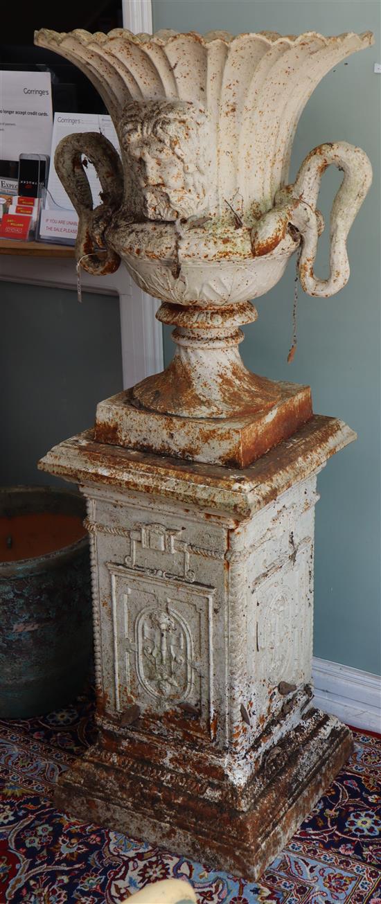 A pair of white campana cast iron garden urns on square plinths H.155cm